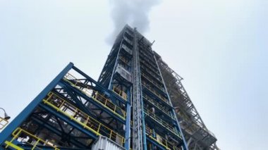 Gökyüzünün bulutlu zeminine karşı petrol rafinerisinde benzin üretmek için kule