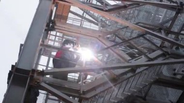 Bir kaynakçı, bir fabrikada metal bir yapının onarımını yapar.