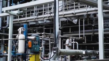 Bir kaynakçı, bir petrol rafinerisindeki boru hattını parlak ışıklar ve kıvılcımlarla onarıyor.