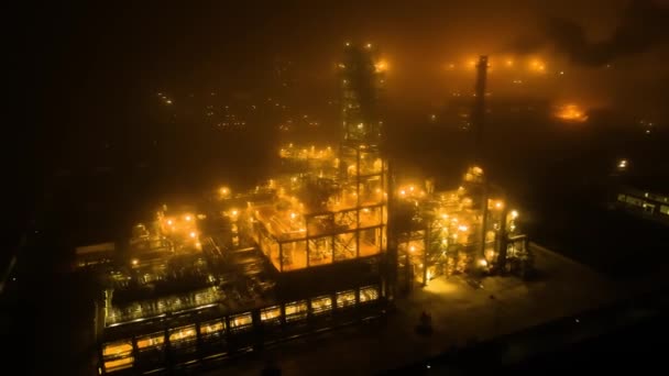 Repülni az olajfinomító mentén egy ködös éjszakán, fényes éjszakai arany világítással. — Stock videók