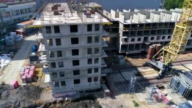 Reinforcement of supporting concrete walls. Installation of steel bars for concrete casting. Workers are building a monolithic house. A tower crane is located at the construction site. Drone footage