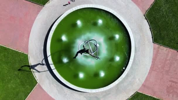 Вид на необычный круглый фонтан с ярко-зеленой водой в золотом вечернем свете — стоковое видео