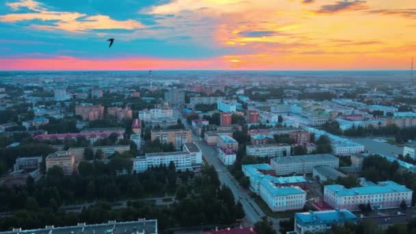 Vista a volo d'uccello della città al tramonto blu. Luminoso cielo arancio tramonto sopra case basse. — Video Stock
