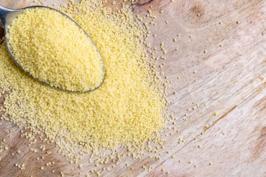 Tahta masadaki kaşıkta kuskus.