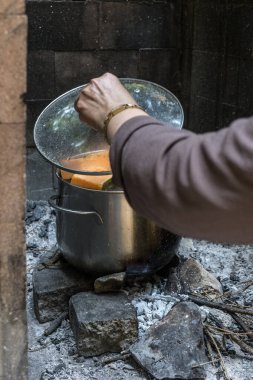 Afrika ormanında bir tencere sebze hazırla, kabağı tencereye ekle doğadaki bir ateşin üzerine, Afrika 'da hayatta kalma kavramında.
