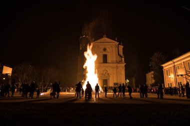 PESCANTINA, VERONA, ITALY, JANUARY, 5, 2020: kilise meydanındaki şenlik ateşi etrafında insanlar