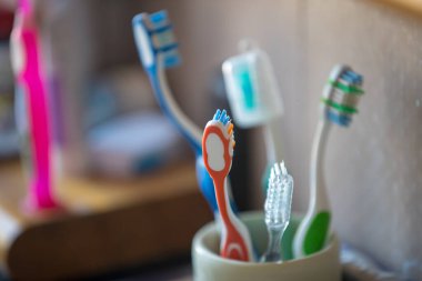 Bulanık arkaplanda bardaktaki diş fırçaları