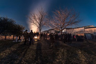 PESCANTINA, VERONA, ITALY, JANUARY, 5, 2020: kilise meydanındaki şenlik ateşi etrafında insanlar