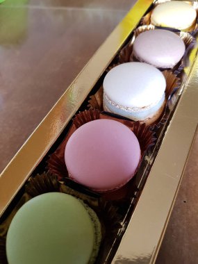 Mağazanın ahşap masasında rengarenk, lezzetli kurabiyeler.