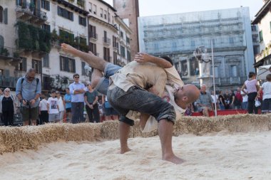 VERONA, ITALY, NOVEMBER, 14, 2019: (Tocat - Uluslararası Sokak Oyunları Festivali), Geleneksel Brittany Oyunları, Breton güreşi, kum ringinde dövüşen iki adam, Lutte Bretonne