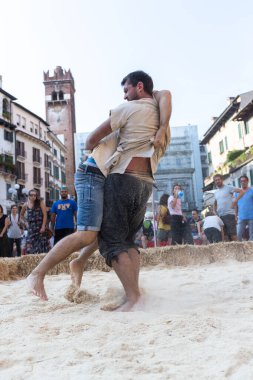 VERONA, ITALY, NOVEMBER, 14, 2019: (Tocat - Uluslararası Sokak Oyunları Festivali), Geleneksel Brittany Oyunları, Breton güreşi, kum ringinde dövüşen iki adam, Lutte Bretonne