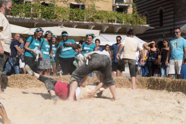 VERONA, ITALY, NOVEMBER, 14, 2019: (Tocat - Uluslararası Sokak Oyunları Festivali), Geleneksel Brittany Oyunları, Breton güreşi, kum ringinde dövüşen iki adam, Lutte Bretonne