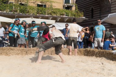 VERONA, ITALY, NOVEMBER, 14, 2019: (Tocat - Uluslararası Sokak Oyunları Festivali), Geleneksel Brittany Oyunları, Breton güreşi, kum ringinde dövüşen iki adam, Lutte Bretonne
