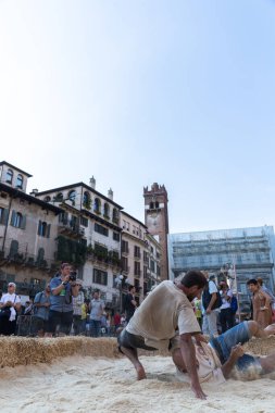 VERONA, ITALY, NOVEMBER, 14, 2019: (Tocat - Uluslararası Sokak Oyunları Festivali), Geleneksel Brittany Oyunları, Breton güreşi, kum ringinde dövüşen iki adam, Lutte Bretonne