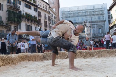 VERONA, ITALY, NOVEMBER, 14, 2019: (Tocat - Uluslararası Sokak Oyunları Festivali), Geleneksel Brittany Oyunları, Breton güreşi, kum ringinde dövüşen iki adam, Lutte Bretonne