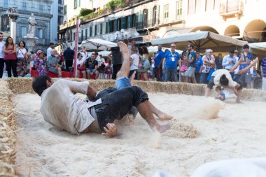 VERONA, ITALY, NOVEMBER, 14, 2019: (Tocat - Uluslararası Sokak Oyunları Festivali), Geleneksel Brittany Oyunları, Breton güreşi, kum ringinde dövüşen iki adam, Lutte Bretonne