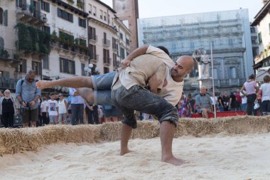 VERONA, ITALY, NOVEMBER, 14, 2019: (Tocat - Uluslararası Sokak Oyunları Festivali), Geleneksel Brittany Oyunları, Breton güreşi, kum ringinde dövüşen iki adam, Lutte Bretonne