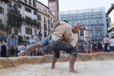VERONA, ITALY, NOVEMBER, 14, 2019: (Tocat - Uluslararası Sokak Oyunları Festivali), Geleneksel Brittany Oyunları, Breton güreşi, kum ringinde dövüşen iki adam, Lutte Bretonne