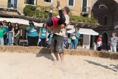 VERONA, ITALY, NOVEMBER, 14, 2019: (Tocat - Uluslararası Sokak Oyunları Festivali), Geleneksel Brittany Oyunları, Breton güreşi, kum ringinde dövüşen iki adam, Lutte Bretonne