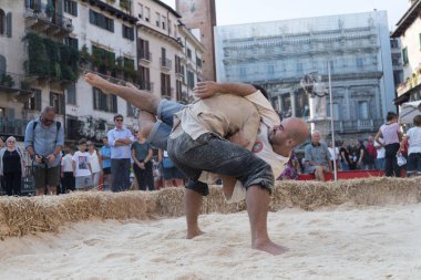 VERONA, ITALY, NOVEMBER, 14, 2019: (Tocat - Uluslararası Sokak Oyunları Festivali), Geleneksel Brittany Oyunları, Breton güreşi, kum ringinde dövüşen iki adam, Lutte Bretonne