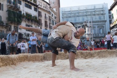 VERONA, ITALY, NOVEMBER, 14, 2019: (Tocat - Uluslararası Sokak Oyunları Festivali), Geleneksel Brittany Oyunları, Breton güreşi, kum ringinde dövüşen iki adam, Lutte Bretonne