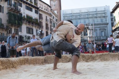 VERONA, ITALY, NOVEMBER, 14, 2019: (Tocat - Uluslararası Sokak Oyunları Festivali), Geleneksel Brittany Oyunları, Breton güreşi, kum ringinde dövüşen iki adam, Lutte Bretonne