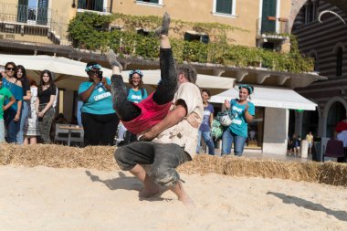 VERONA, ITALY, NOVEMBER, 14, 2019: (Tocat - Uluslararası Sokak Oyunları Festivali), Geleneksel Brittany Oyunları, Breton güreşi, kum ringinde dövüşen iki adam, Lutte Bretonne