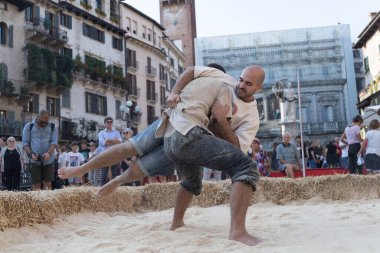 VERONA, ITALY, NOVEMBER, 14, 2019: (Tocat - Uluslararası Sokak Oyunları Festivali), Geleneksel Brittany Oyunları, Breton güreşi, kum ringinde dövüşen iki adam, Lutte Bretonne