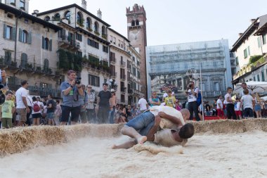 VERONA, ITALY, NOVEMBER, 14, 2019: (Tocat - Uluslararası Sokak Oyunları Festivali), Geleneksel Brittany Oyunları, Breton güreşi, kum ringinde dövüşen iki adam, Lutte Bretonne