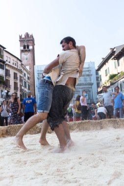 VERONA, ITALY, NOVEMBER, 14, 2019: (Tocat - Uluslararası Sokak Oyunları Festivali), Geleneksel Brittany Oyunları, Breton güreşi, kum ringinde dövüşen iki adam, Lutte Bretonne