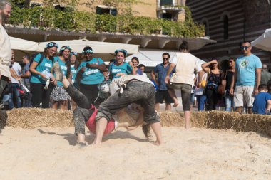 VERONA, ITALY, NOVEMBER, 14, 2019: (Tocat - Uluslararası Sokak Oyunları Festivali), Geleneksel Brittany Oyunları, Breton güreşi, kum ringinde dövüşen iki adam, Lutte Bretonne