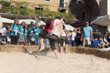 VERONA, ITALY, NOVEMBER, 14, 2019: (Tocat - Uluslararası Sokak Oyunları Festivali), Geleneksel Brittany Oyunları, Breton güreşi, kum ringinde dövüşen iki adam, Lutte Bretonne