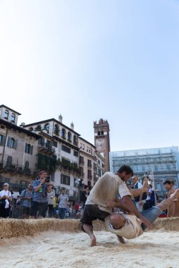 VERONA, ITALY, NOVEMBER, 14, 2019: (Tocat - Uluslararası Sokak Oyunları Festivali), Geleneksel Brittany Oyunları, Breton güreşi, kum ringinde dövüşen iki adam, Lutte Bretonne