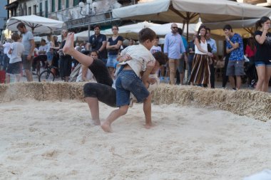 VERONA, ITALY, NOVEMBER, 14, 2019: (Tocat - Uluslararası Sokak Oyunları Festivali), Geleneksel Brittany Oyunları, Breton güreşi, kum ringinde dövüşen iki çocuk, Lutte Bretonne