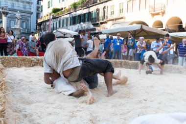 VERONA, ITALY, NOVEMBER, 14, 2019: (Tocat - Uluslararası Sokak Oyunları Festivali), Geleneksel Brittany Oyunları, Breton güreşi, kum ringinde dövüşen iki adam, Lutte Bretonne