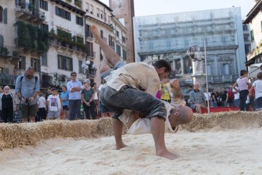 VERONA, ITALY, NOVEMBER, 14, 2019: (Tocat - Uluslararası Sokak Oyunları Festivali), Geleneksel Brittany Oyunları, Breton güreşi, kum ringinde dövüşen iki adam, Lutte Bretonne