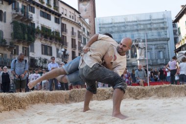 VERONA, ITALY, NOVEMBER, 14, 2019: (Tocat - Uluslararası Sokak Oyunları Festivali), Geleneksel Brittany Oyunları, Breton güreşi, kum ringinde dövüşen iki adam, Lutte Bretonne