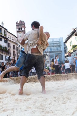 VERONA, ITALY, NOVEMBER, 14, 2019: (Tocat - Uluslararası Sokak Oyunları Festivali), Geleneksel Brittany Oyunları, Breton güreşi, kum ringinde dövüşen iki adam, Lutte Bretonne