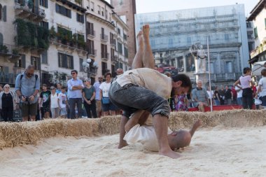 VERONA, ITALY, NOVEMBER, 14, 2019: (Tocat - Uluslararası Sokak Oyunları Festivali), Geleneksel Brittany Oyunları, Breton güreşi, kum ringinde dövüşen iki adam, Lutte Bretonne