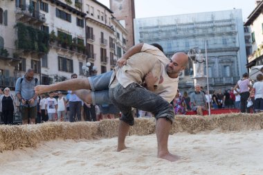 VERONA, ITALY, NOVEMBER, 14, 2019: (Tocat - Uluslararası Sokak Oyunları Festivali), Geleneksel Brittany Oyunları, Breton güreşi, kum ringinde dövüşen iki adam, Lutte Bretonne