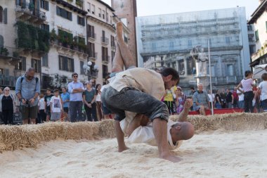VERONA, ITALY, NOVEMBER, 14, 2019: (Tocat - Uluslararası Sokak Oyunları Festivali), Geleneksel Brittany Oyunları, Breton güreşi, kum ringinde dövüşen iki adam, Lutte Bretonne