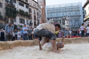 VERONA, ITALY, NOVEMBER, 14, 2019: (Tocat - Uluslararası Sokak Oyunları Festivali), Geleneksel Brittany Oyunları, Breton güreşi, kum ringinde dövüşen iki adam, Lutte Bretonne