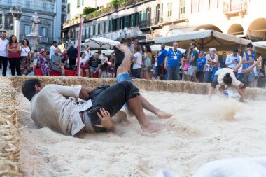 VERONA, ITALY, NOVEMBER, 14, 2019: (Tocat - Uluslararası Sokak Oyunları Festivali), Geleneksel Brittany Oyunları, Breton güreşi, kum ringinde dövüşen iki adam, Lutte Bretonne