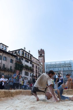 VERONA, ITALY, NOVEMBER, 14, 2019: (Tocat - Uluslararası Sokak Oyunları Festivali), Geleneksel Brittany Oyunları, Breton güreşi, kum ringinde dövüşen iki adam, Lutte Bretonne