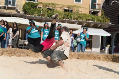 VERONA, ITALY, NOVEMBER, 14, 2019: (Tocat - Uluslararası Sokak Oyunları Festivali), Geleneksel Brittany Oyunları, Breton güreşi, kum ringinde dövüşen iki adam, Lutte Bretonne