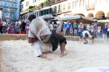 VERONA, ITALY, NOVEMBER, 14, 2019: (Tocat - Uluslararası Sokak Oyunları Festivali), Geleneksel Brittany Oyunları, Breton güreşi, kum ringinde dövüşen iki adam, Lutte Bretonne