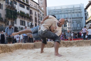 VERONA, ITALY, NOVEMBER, 14, 2019: (Tocat - Uluslararası Sokak Oyunları Festivali), Geleneksel Brittany Oyunları, Breton güreşi, kum ringinde dövüşen iki adam, Lutte Bretonne