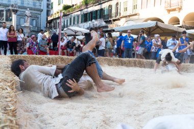 VERONA, ITALY, NOVEMBER, 14, 2019: (Tocat - Uluslararası Sokak Oyunları Festivali), Geleneksel Brittany Oyunları, Breton güreşi, kum ringinde dövüşen iki adam, Lutte Bretonne