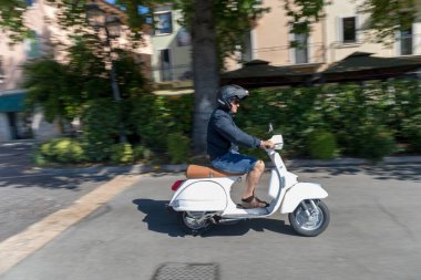 PESCANTINA, VERONA, ITALY, 23 Haziran 2019: Vespa motorsikletini süren motosikletçi