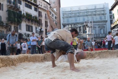 VERONA, ITALY, NOVEMBER, 14, 2019: (Tocat - Uluslararası Sokak Oyunları Festivali), Geleneksel Brittany Oyunları, Breton güreşi, kum ringinde dövüşen iki adam, Lutte Bretonne